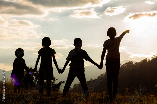 Group children standing looking sunset on mountain