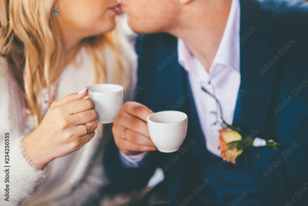 Closeup of couple kissing with cups in hands Closeup of couple kissing with cups in hands
