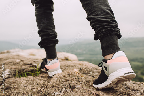 Athlete trail running in the mountains on rocky terrain  sports shoes detail.Runner running rocks in mountain.