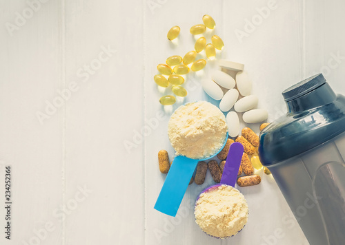 Sport food supplements. Sport Pills, vitamins and protein powder with bottle composed on the white table