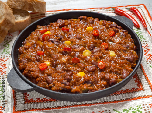 Texas chili. Chili con carne in frying pan on white wooden background. 
