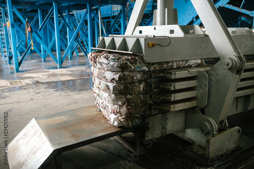 Special equipment for pressing paper waste at a waste sorting plant for further disposal or recycling. photo