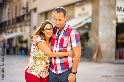 Young woman hugging husband in the middle of European city