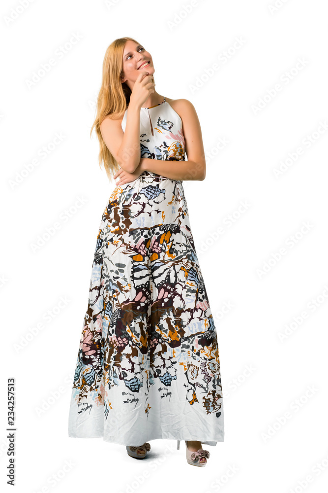 Blonde young girl in a summer dress standing and thinking an idea while looking up on isolated white backgroun Blonde young girl in a summer dress standing and thinking an idea while looking up on isolated white backgroun