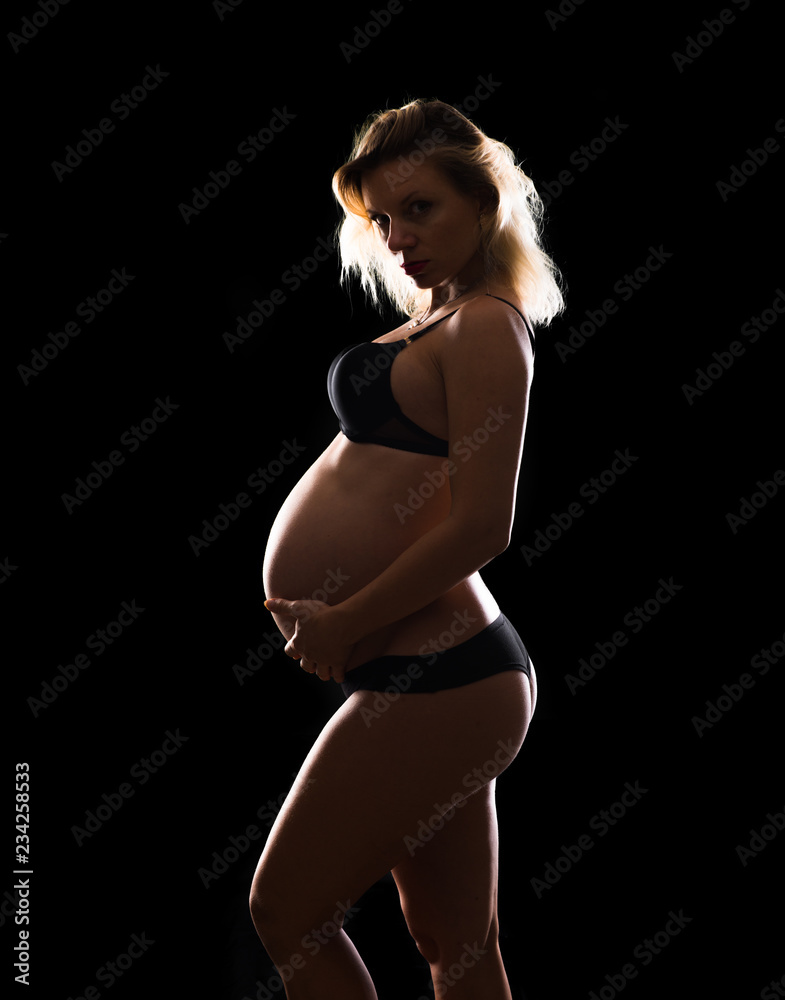 Obraz premium Artistic silhouette of blonde pregnant woman on isolated background
