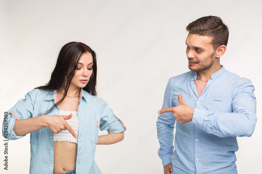 People and gesture concept - young pretty woman and handsome man pointing down over white background People and gesture concept - young pretty woman and handsome man pointing down over white background