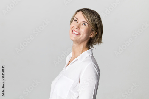 Amazing and cheerful smiling blonde in white shirt studio shot, isolated on white