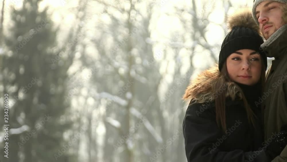 Beautiful couple spent time in the park. They hug each other. Snowy weather Beautiful couple spent time in the park. They hug each other. Snowy weather