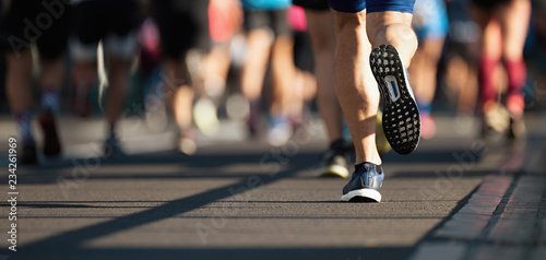 Marathon runners running on city road,detail on legs