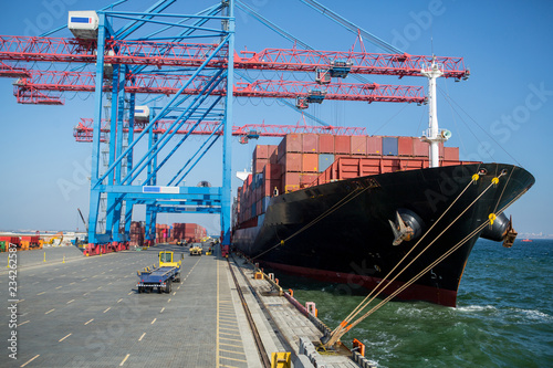 Container ship in port at container terminal. Ships of container ships stand in terminal of port on loading, unloading container.