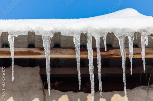 Icicles hang from the roof in winter © schankz