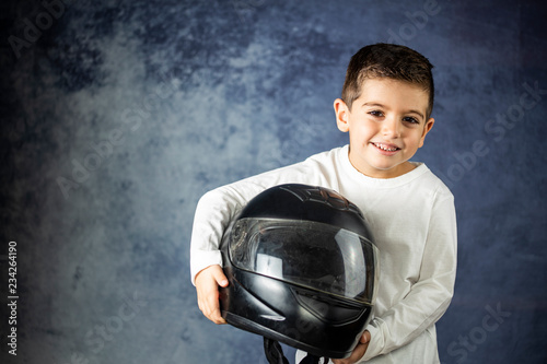 Little kid playing with a motorcycle helmet photo