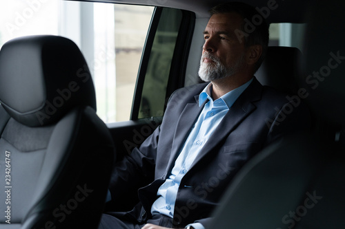 transport, business trip and people concept - senior businessman driving on car back seat. © opolja