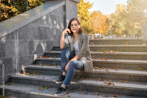 Beautiful young woman sitti...