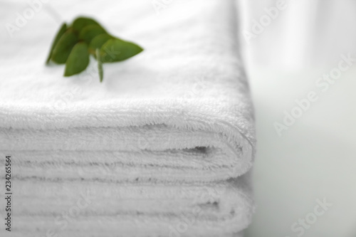 Folded white soft towels on light table, closeup