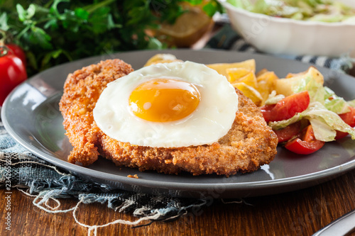 Breaded viennese schnitzel with fried agg photo