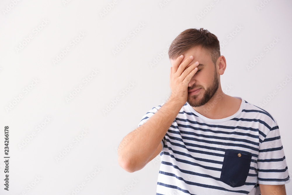 Emotional young man after making mistake on white background Emotional young man after making mistake on white background
