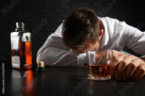 Drunk man with whiskey at t...