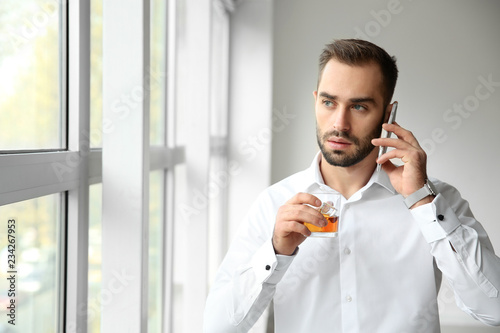 Young man with glass on whi...
