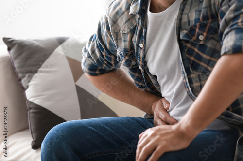 Man suffering from abdominal pain at home