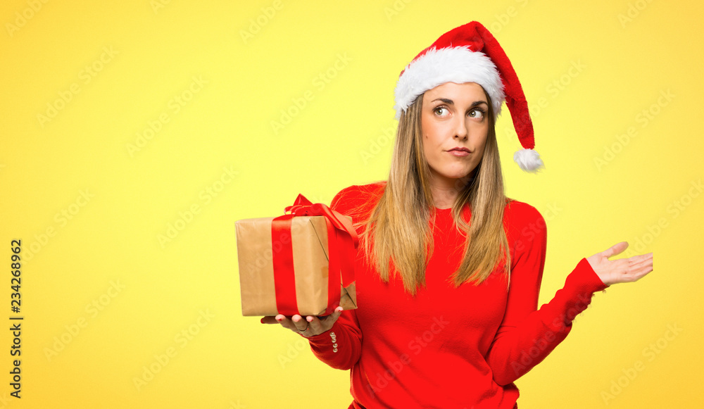 Blonde woman dressed up for christmas holidays having doubts and with confuse face expression on yellow background Blonde woman dressed up for christmas holidays having doubts and with confuse face expression on yellow background