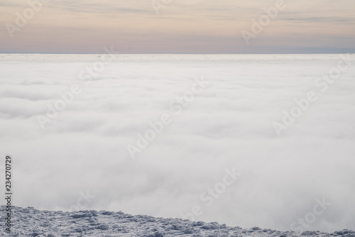 Above white heavy clouds. Panorama of cloudscape from the top of the mountain.