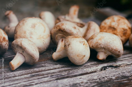 Fresh raw champignon mushrooms on wooden table. Cooking process. Modern kitchen.