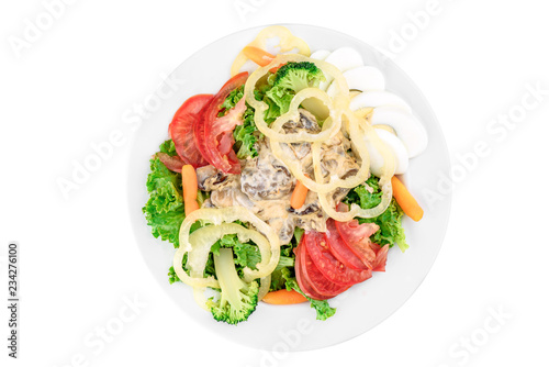 Salad with tomatoes, bell pepper, mushrooms, boiled egg, broccoli and carrots in a white plate isolated on white background. top view. flat lay