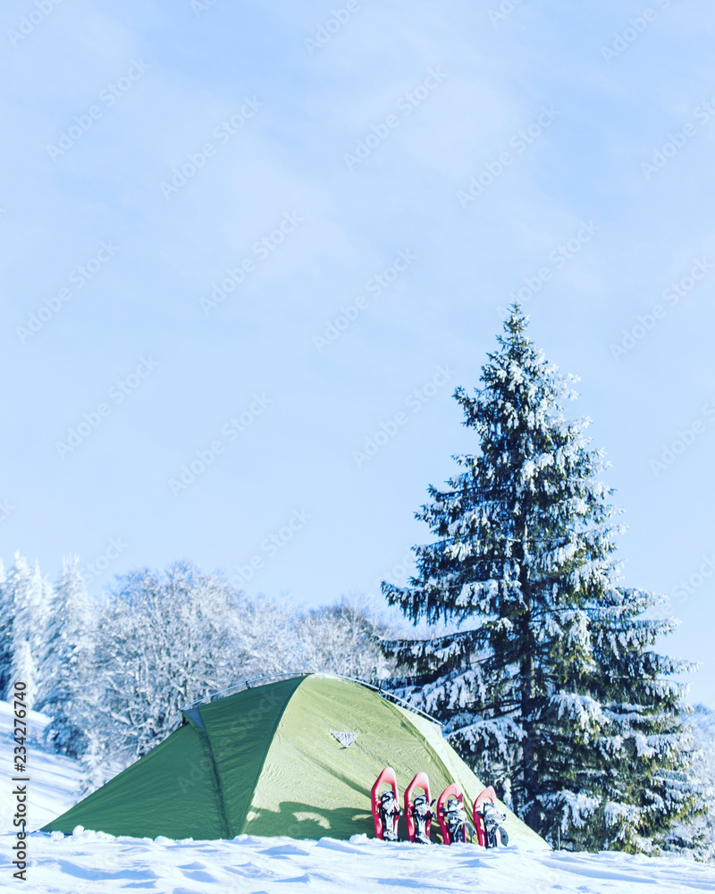 Winter hike in the mountains. Snowshoes are in the snow near the tent. Winter hike in the mountains. Snowshoes are in the snow near the tent.