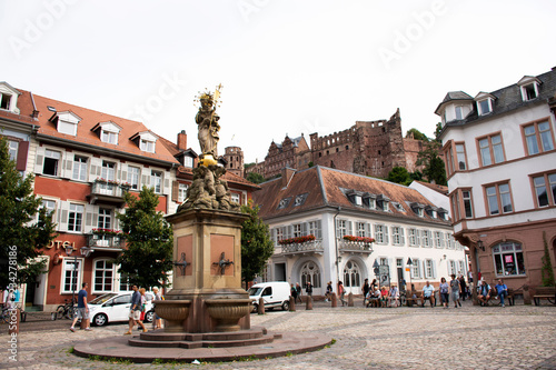 German and foreigner travelers people walking and visit madonna statue at the corn market square in Heidelberg, Germany