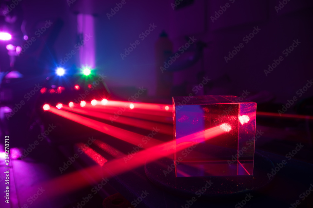 Experiments with lasers in the optics lab. Red laser on optical table in physics laboratory Experiments with lasers in the optics lab. Red laser on optical table in physics laboratory