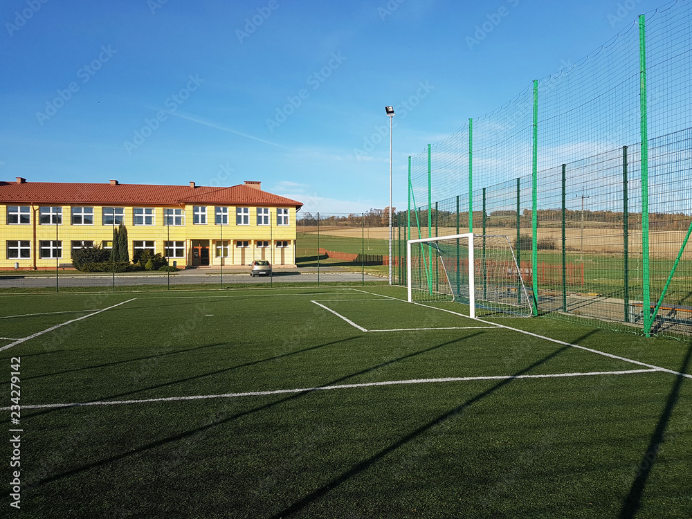 Wisniowa, Poland - 9 9 2018:An open stadium in the courtyard of a village school. Eduction of the younger generation. Sports ground for football, volleyball and basketball. Lighting on natural sources