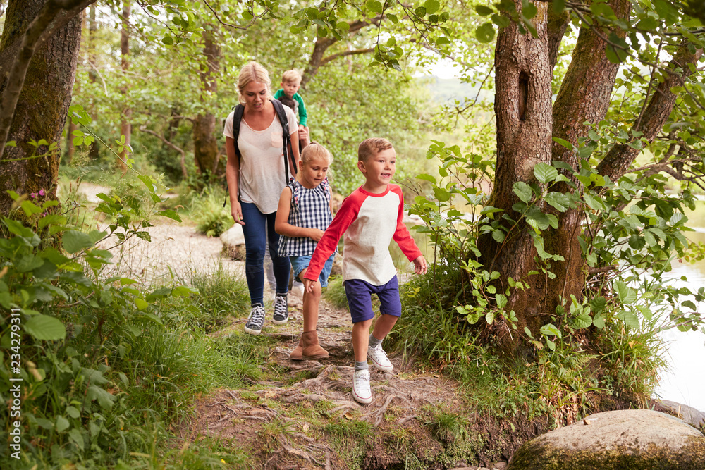 Family Hiking Along Path By River In UK Lake District Family Hiking Along Path By River In UK Lake District