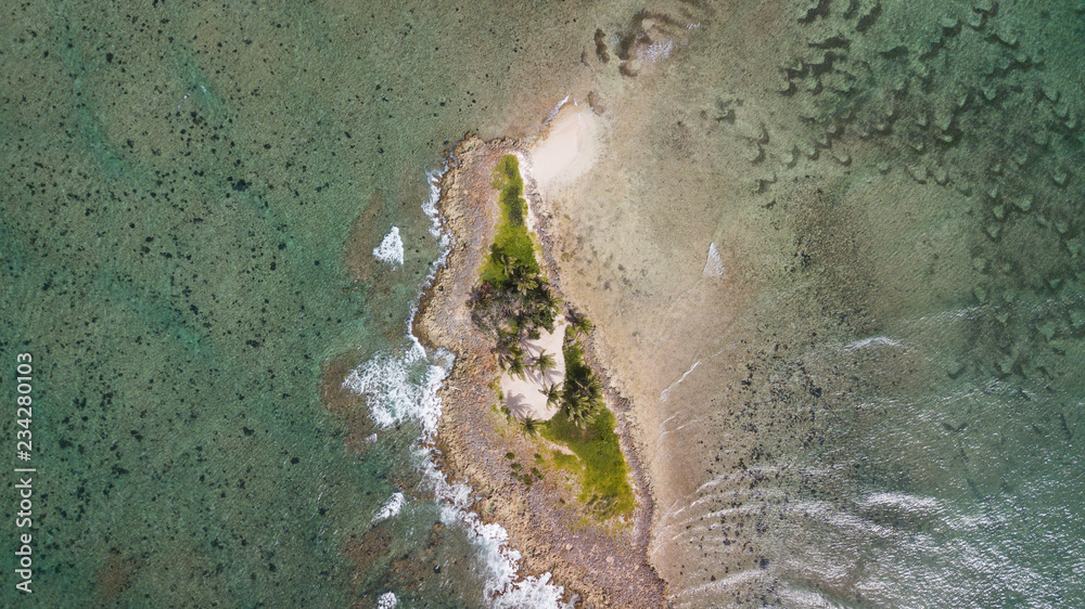 Small desert island in the ocean. Tropical island above top view. Aerial view