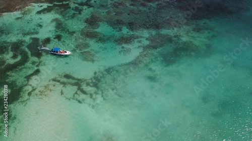 Boats on the sea. The boat is floating on the emerald clear sea between coral reefs. Aerial view