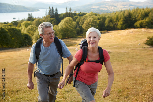 Senior Couple Climbing Hill On Hike Through Countryside In Lake District UK Together © Monkey Business
