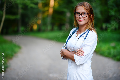 Obraz na płótnie It looks beautiful. a young girl who is a doctor stands outside, w salonie