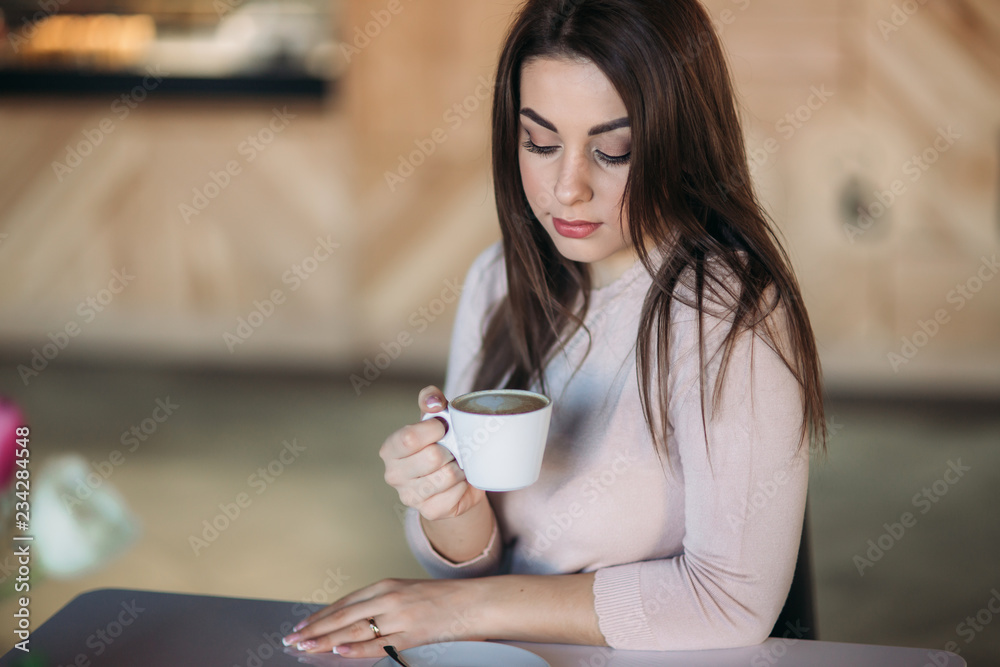 Beautiful girl siting in cafe and drinking cappuccino Beautiful girl siting in cafe and drinking cappuccino