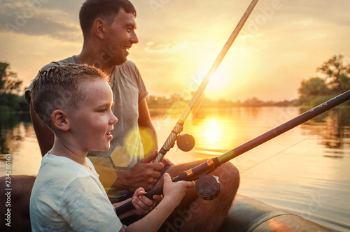 Photography Happy Father and Son together fishing from a boat at sunset time