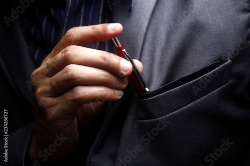 Принти на полотні Man inserting a pen to his suit's pocket
