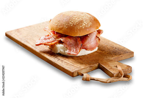 Bacon roll on a wooden board.