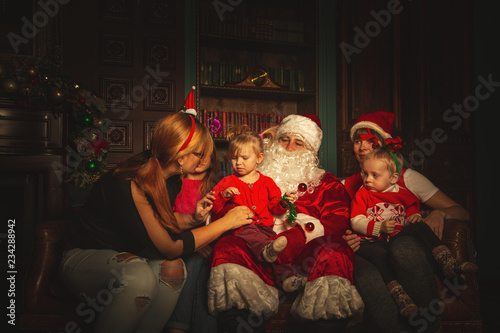 Christmas family portrait in a festive living room with a real Santa Claus. © lizavetta
