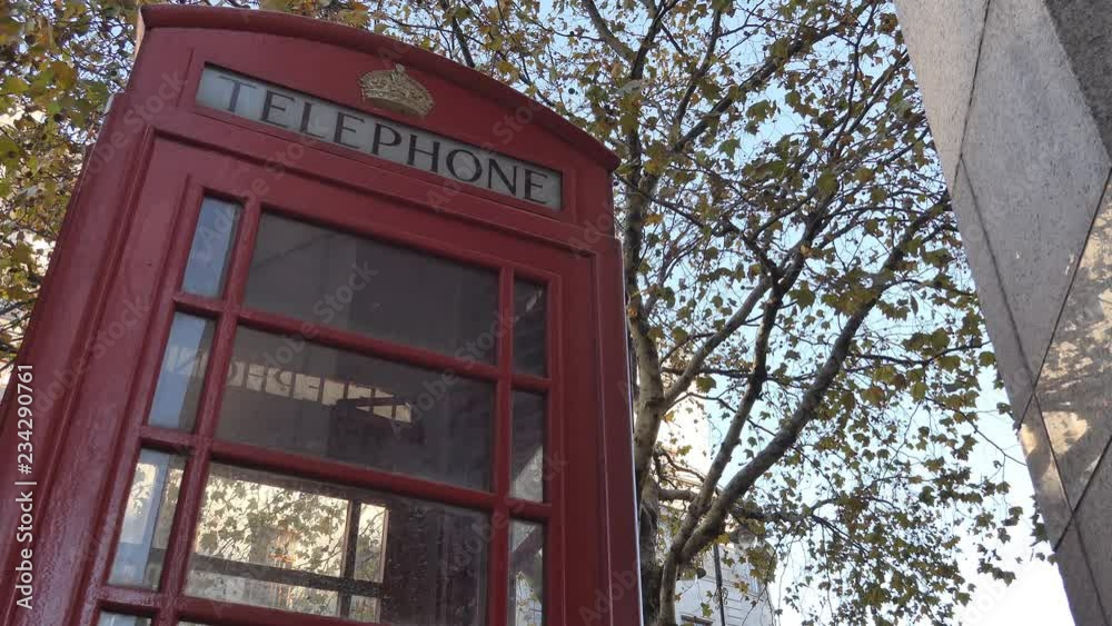 A red telephone booth in the street in autumn. London. A red telephone booth in the street in autumn. London.