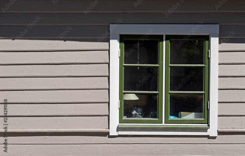 Sprossenfenster auf grauer Bretterfassade