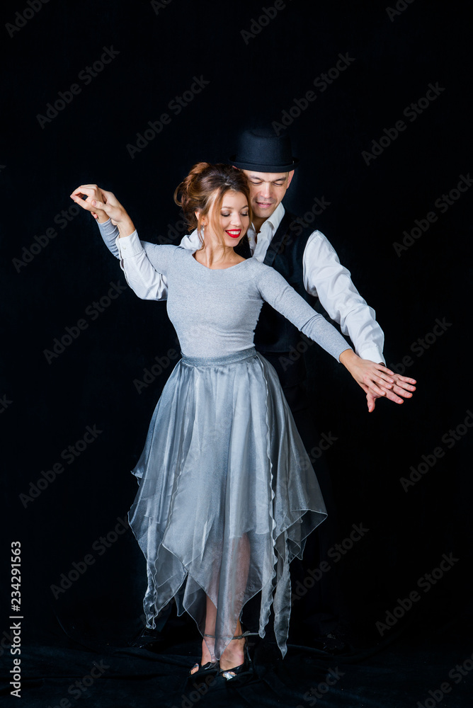 Fototapeta premium man and woman dancing Latin, ballroom dancing in a pair on a black background, dance moves