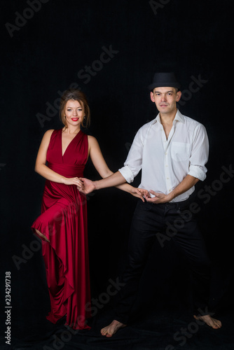 dancers on a black background, Latin ballroom dancing man and woman in a pair