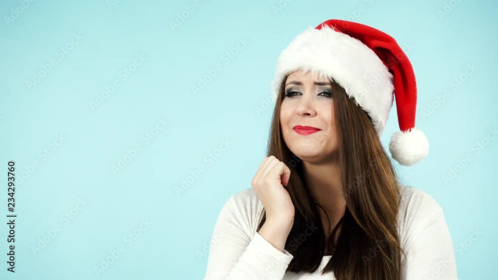 Tired young woman in santa claus hat yawning. Christmas holidays. Tired young woman in santa claus hat yawning. Christmas holidays.