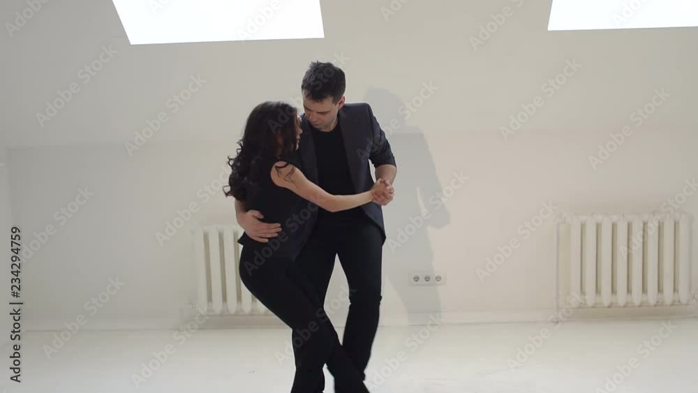 Young couple dancing the salsa at the dance hall. Sensual young people are dancing professional ballroom dances in a dance studio.