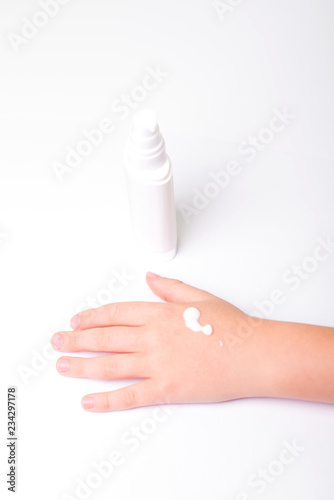 Children's hands and cream in a white tube. On white background. Baby skin care.
