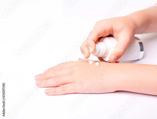 Children's hands and cream in a white tube. On white background. Baby skin care.